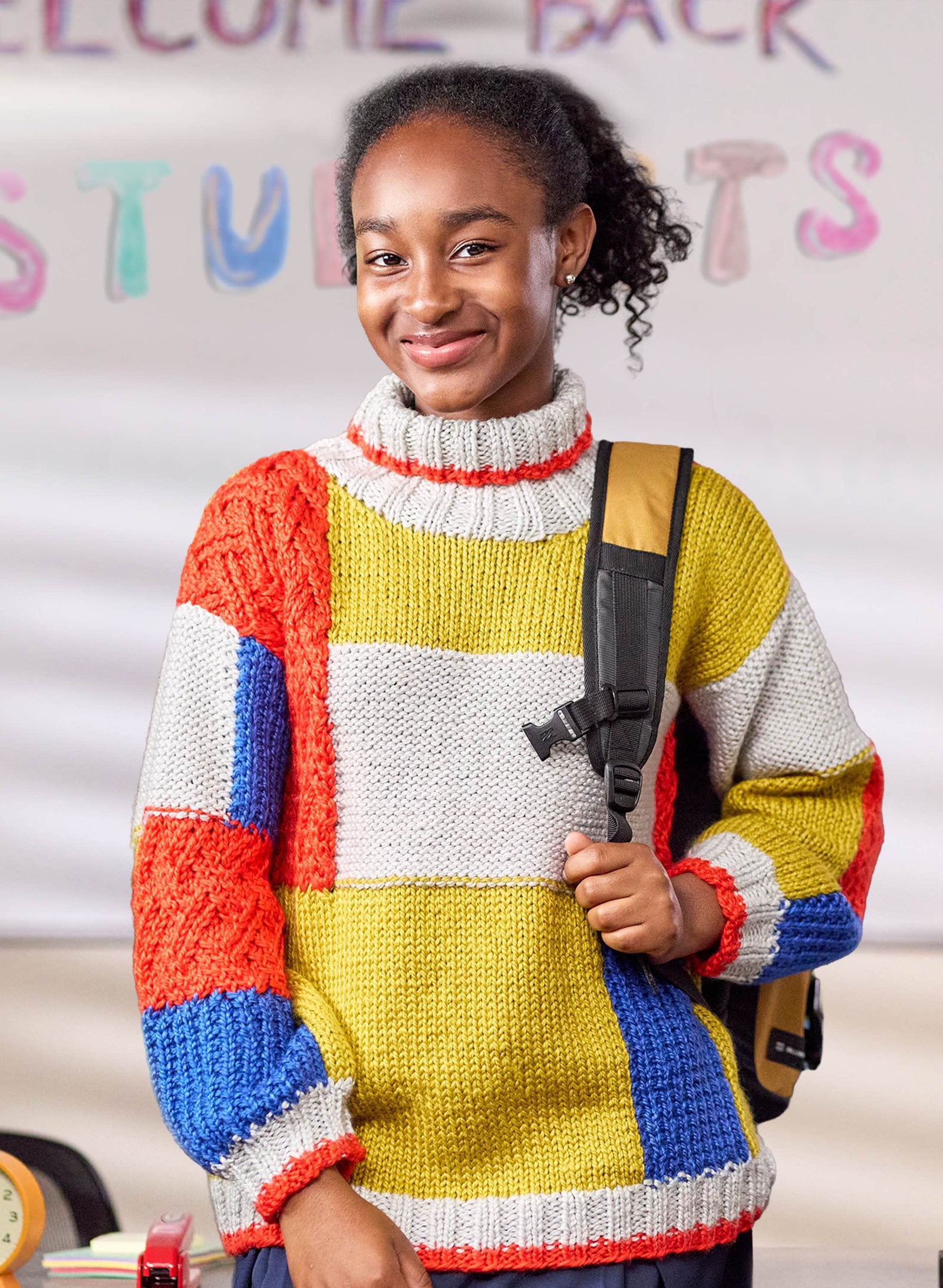 Student in a classroom wearing a handmade knit colorblock patchwork pullover pattern